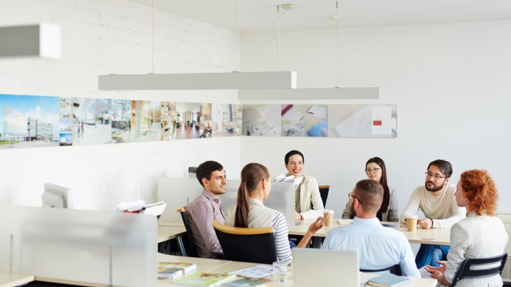 Psychologische Sicherheit schaffen: Teammitglieder, die im Büro zusammensitzen und miteinander sprechen